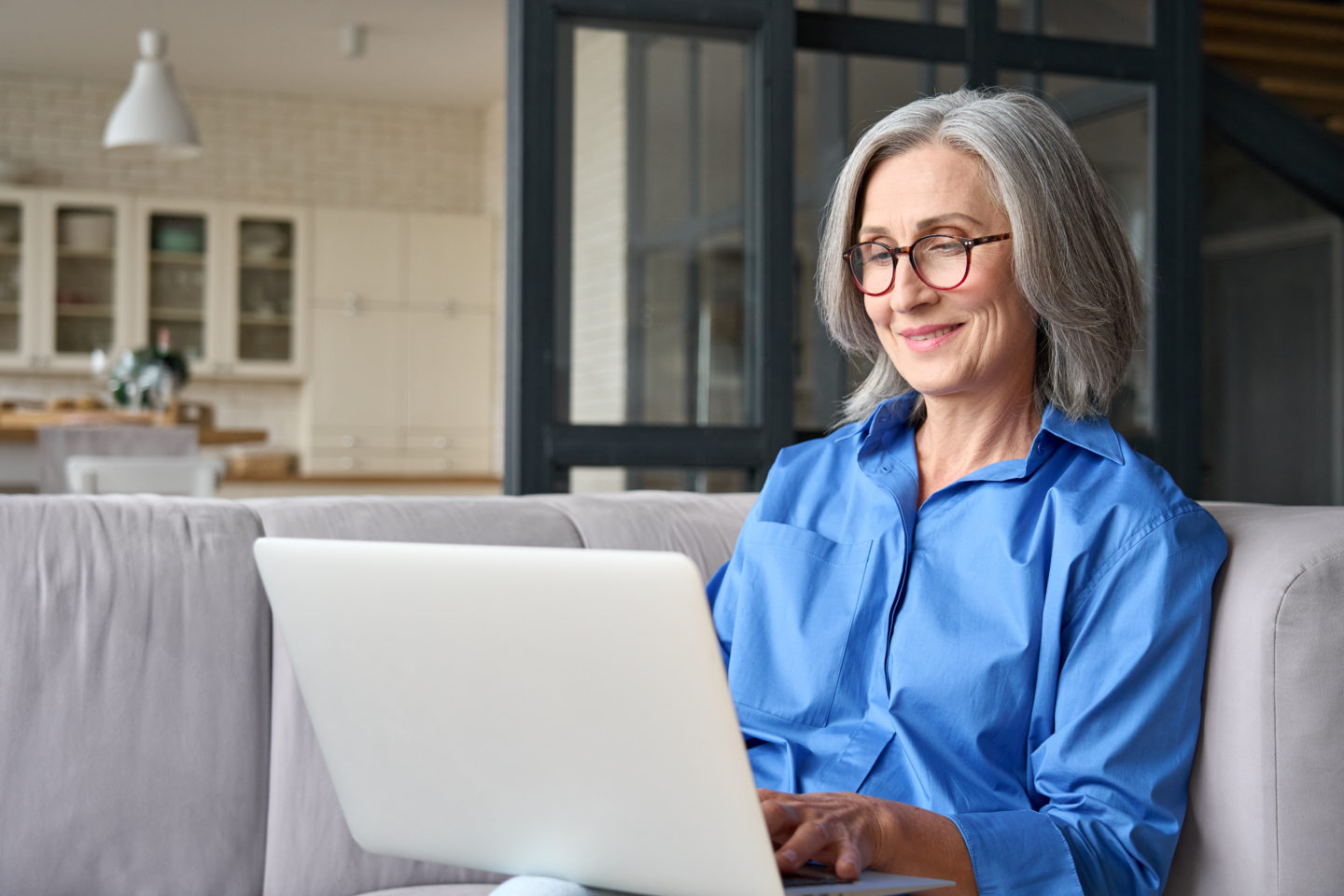 https://www.baywater.co.uk/app/uploads/Older-smiling-60s-woman-sitting-at-home-on-sofa-holding-laptop-1440x960.jpeg